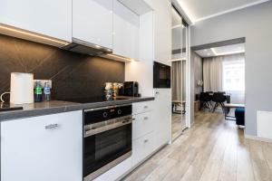 een keuken met witte kasten en een fornuis bij Apartament Arena Gliwice Budget in Gliwice