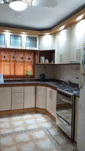 cocina con armarios blancos y fogones en A 4 cuadras del ORFEO Alto verde 2 dormitorios en Córdoba