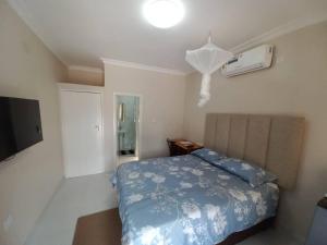 1 dormitorio con 1 cama con manta azul en Kasuda Rooms - Cosy self contained rooms, en Livingstone