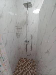 a shower in a bathroom with a checkered floor at Kasuda Rooms - Cosy self contained rooms in Livingstone