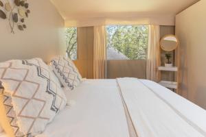 a bedroom with a white bed with a window at Emhosheni River Lodge in Balule Game Reserve