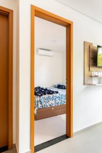 a mirror in a bedroom with a bed in it at Maracaipe, um paraíso para você - Maraca Beach Residence II - ap 111 in Ipojuca