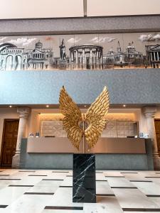 a large gold butterfly sculpture in a lobby at Hotel Real Maestranza in Guadalajara