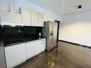 a kitchen with white cabinets and a stainless steel refrigerator at Pensjonat Jachranka in Jachranka