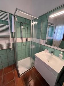 y baño con ducha acristalada y lavamanos. en Agriturismo Tenuta de Castro en Aprilia