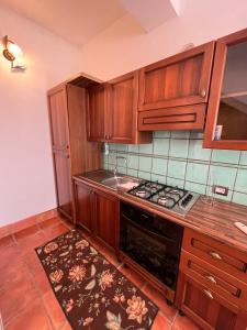 a kitchen with wooden cabinets and a stove top oven at Agriturismo Tenuta de Castro in Aprilia +17 photos