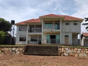 a large white house with stairs in front of it at Stand alone gateway in Kampala
