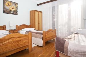 a bedroom with three beds and a window at Guesthouse Rutar in Rupa