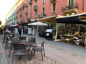 un grupo de mesas y sillas en una calle de la ciudad en Appartamento Navigli, en Milán