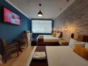 une chambre d'hôtel avec un lit et un canapé dans l'établissement Hostal Atenea, à Ilo