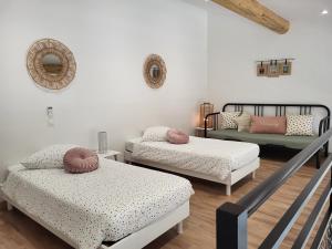 Cette chambre comprend deux lits et un canapé. dans l'établissement Pâquerette, à Arles