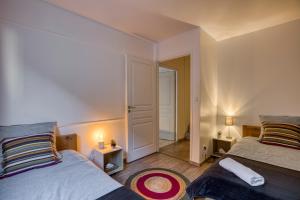 een slaapkamer met 2 bedden en een deur naar een gang bij Charmant T3 - centre ville - proche du lac in Annecy