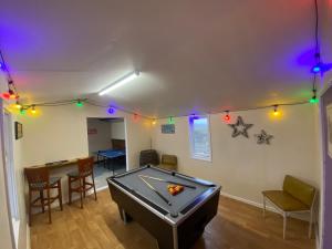 a living room with a pool table and lights at Stags Hide in Minwear