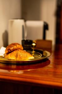 a plate of bread and croissants on a table at LivingRoom 2 Heritage Hydromassage Bath Self Check-in 24h in Katowice +17 photos