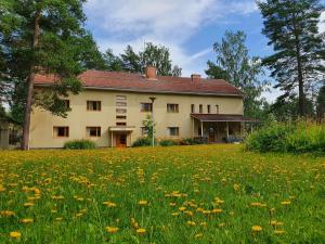a house with a field of flowers in front of it at Hostelli Kotiranta in Lieksa