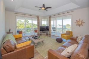 a living room with leather couches and a television at 619 Porpoise Circle in St. Helena Island