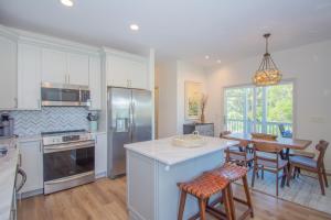 a kitchen with white cabinets and a table with chairs at 619 Porpoise Circle in St. Helena Island
