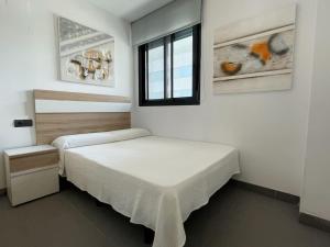 A bed or beds in a room at Apartamento moderno para disfrutar con la familia con parking y piscina