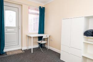a room with a desk and a window and a door at Shirley House 3, Guest House, Self Catering, Self Check in with Smart Locks, Use of Fully Equipped Kitchen, close to City Centre, Ideal for Longer Stays, Walking Distance to BAT, 20 min Drive to Fawley Refinery, Excellent Transport Links in Southampton