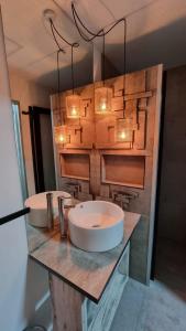 a bathroom with two sinks on a counter with lights at okeyloft Coyhaique 1 in Coihaique