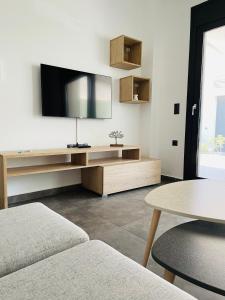 a living room with a flat screen tv on the wall at GEMINI VILLAS NIKITI in Nikiti