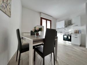 una mesa de comedor con 2 sillas y un jarrón de flores en Diamond apartment, en Arezzo 18 fotos más