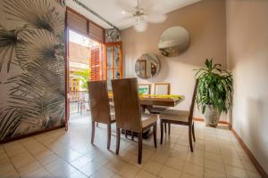ein Esszimmer mit einem Tisch, Stühlen und einer Pflanze in der Unterkunft San Pedro Claver Luxury in the walled city in Cartagena de Indias