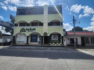 a white building with a sign on it at Nakum Hotel in Flores