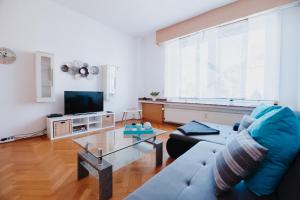 ein Wohnzimmer mit einem blauen Sofa und einem TV in der Unterkunft Ferienwohnung Oberhausen Sterkrade in Oberhausen