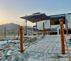 a patio with an umbrella and a table at Al shalal caravan in Fujairah