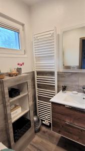 ein Bad mit einem Waschbecken und einem Spiegel in der Unterkunft Ferienhaus Kirschblüte in Monschau