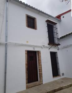 un edificio bianco con tre finestre e una porta di Casa Rural Los Naranjos a Constantina
