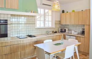 cocina con mesa blanca y sillas blancas en Cozy Home In Lanon-provence With Private Swimming Pool, Can Be Inside Or Outside, en Lançon-Provence