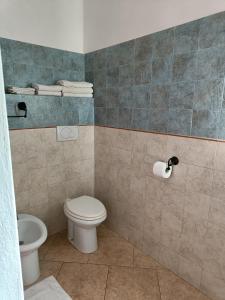 a bathroom with a toilet and a toilet paper roll at Agriturismo Fontelupo in Bracciano