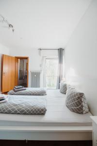 2 Betten in einem weißen Zimmer mit Fenster in der Unterkunft Ferienwohnung Oberhausen Sterkrade in Oberhausen