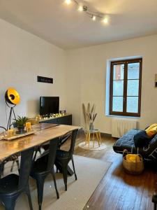 a living room with a table and chairs and a couch at Au fil des étoiles in Selles-sur-Cher