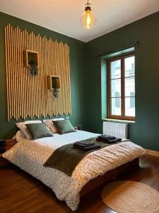 a bedroom with a large bed with green walls at Au fil des étoiles in Selles-sur-Cher