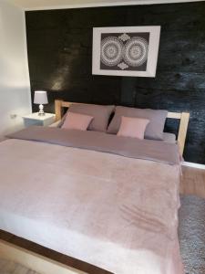 a bedroom with a large bed with pink pillows at Kuća za odmor Tupek in Zagreb