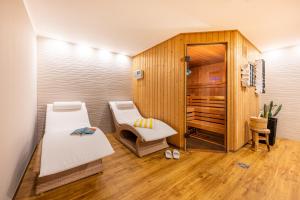 a sauna with two beds and a chair in a room at Centralhotel Binz in Binz