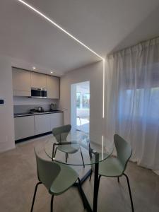 REale Apartments في تيراتشينا: غرفة طعام مع طاولة وكراسي زجاجية