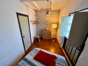 een kamer met een bed met een rood kussen erop bij Loft Borines in Borines +4 foto's