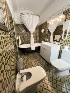 Le Riad Palais d'hotes Suites & Spa Fes في فاس: حمام مع حوض ومرحاض وحوض استحمام