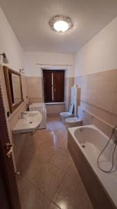 ein Badezimmer mit zwei Waschbecken, einer Badewanne und einem WC in der Unterkunft Casa TRICAGLIO in Barisciano