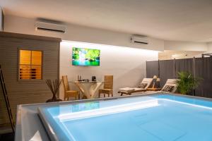 - un salon avec une piscine et une télévision dans l'établissement Residence Le Palme, à Torrazza Piemonte