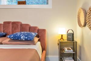 um quarto com uma cama com almofadas azuis e um candeeiro em Boutique em Vancouver