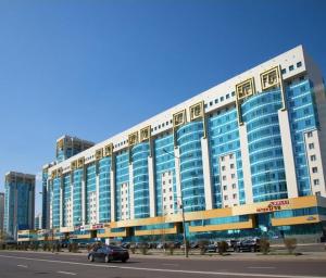 a large building with a car driving in front of it at 27 1 комн кв с кондиционером возле Байтерка на 4х человек in Astana