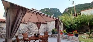 a patio with a table and chairs and an umbrella at ΑΝΕΞΑΡΤΗΤΟ STUDIO ΣΤΟ ΟΜΟΡΦΟ ΚΑΣΤΟΡΕΙΟ in Kastórion