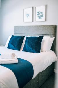 a bedroom with two beds with blue and white pillows at Freda House By Horizon Stays in Sunderland