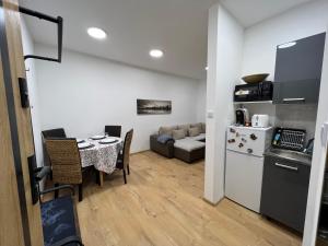 a kitchen and living room with a table and a couch at ApartmentsByMatyrafa-I in Tarnowskie Góry