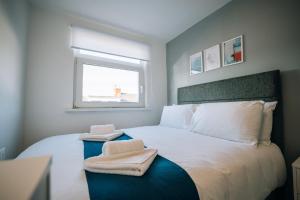 a bedroom with a bed with two towels on it at Freda House By Horizon Stays in Sunderland
